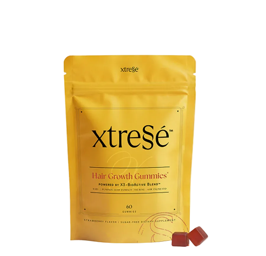 A yellow stand-up pouch of xtreSe Hair Growth Gummies with two small red gummies in front, photographed on a clean white background.